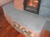 The front bench of the heater is created by one huge slab of soapstone more than four feet wide and twenty inches deep at its largest end.  More wood storage means dry fuel is readily available for the next firing.