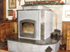This photo was taken shortly after construction was completed and the heater had been fired a few times.  The finished design eliminated stucco in favor of more soapstone.  And rather than absolute black granite, this granite has golden brown speckles.  The glossy granite and matte-finish soapstone go together well.